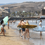 Instructor teaching someone how to surf near the shore