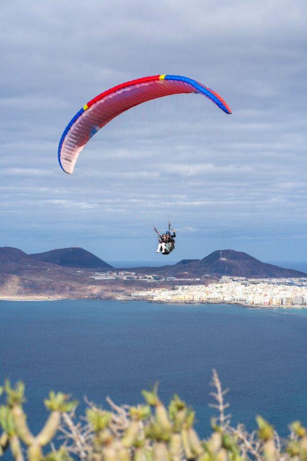Person paragliding with the view of the sea.