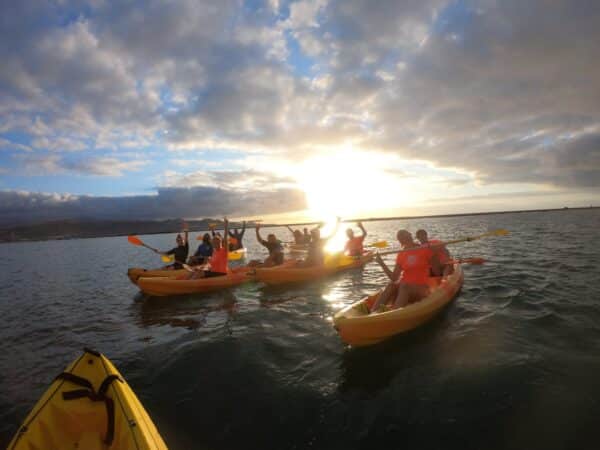 People on kayaks at sunset.