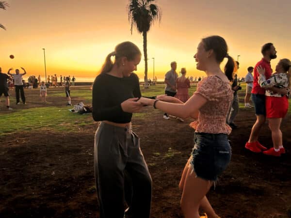 Two girls dancing at sunset.