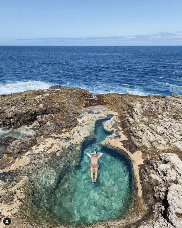 Person floating in a natural pool.