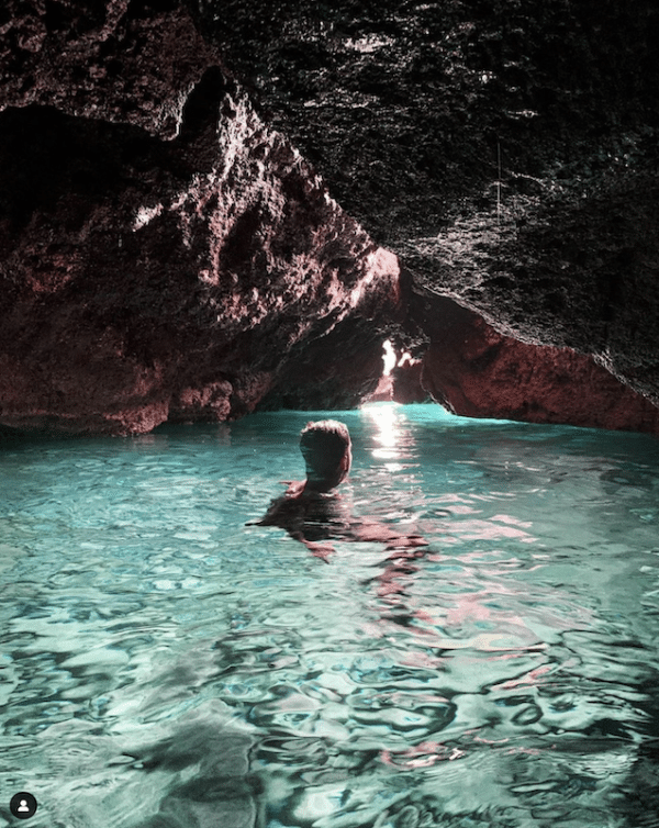 Person swimming inside a cave.