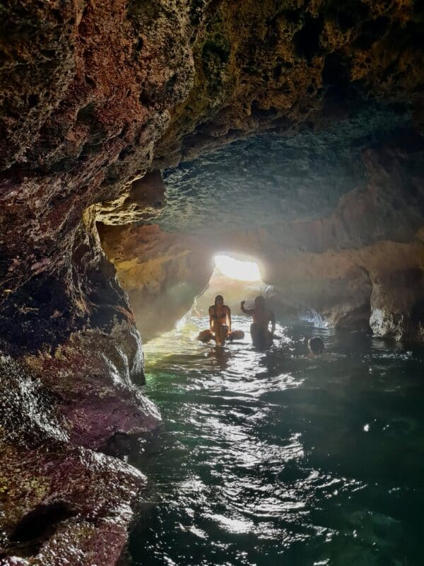 Group of people swimming in a cave.