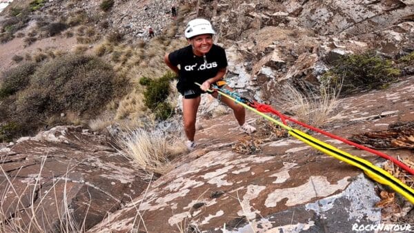 Person climbing on a wall with ropes.