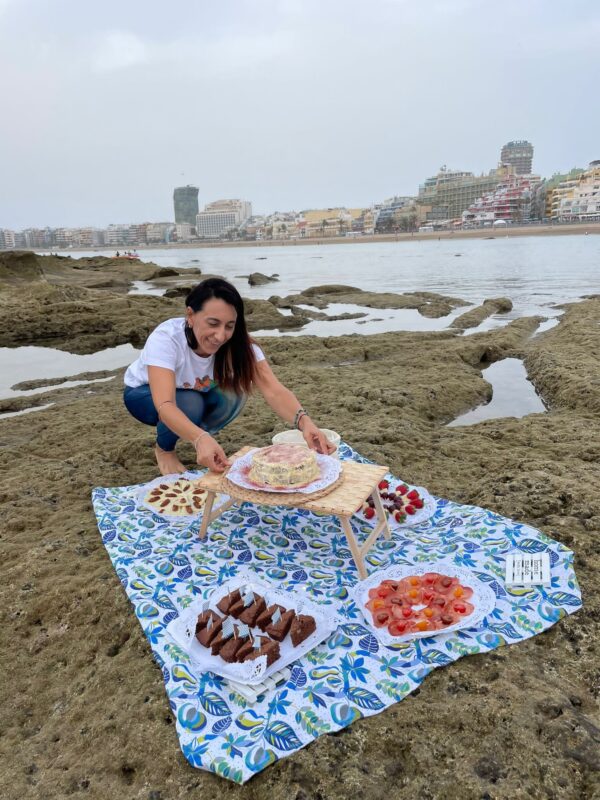 Woman setting up a picnic on the beach.