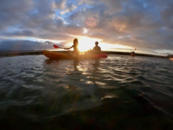 Couple kayaking at sunset.
