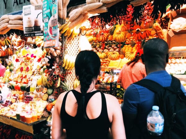 People at a fruit stand in the market.
