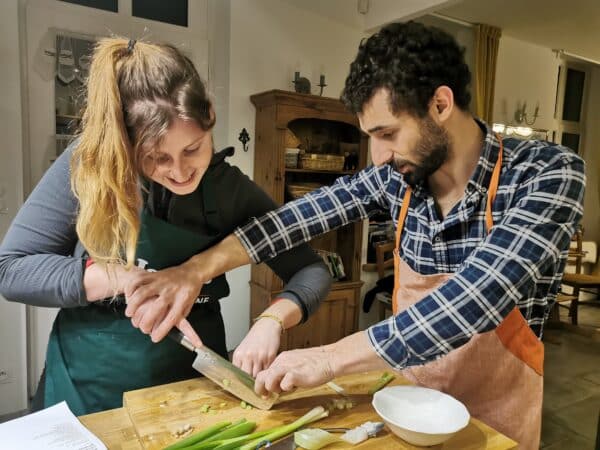 Two people chopping vegetables together.