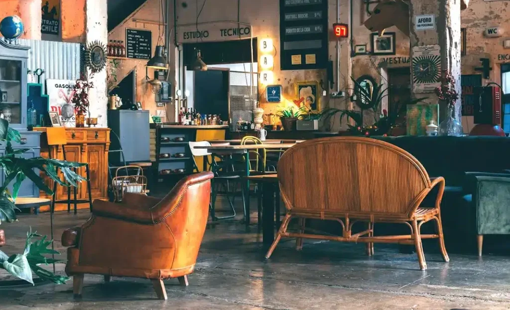 A spacious coworking space filled with various furniture pieces and numerous indoor plants, creating a vibrant atmosphere.